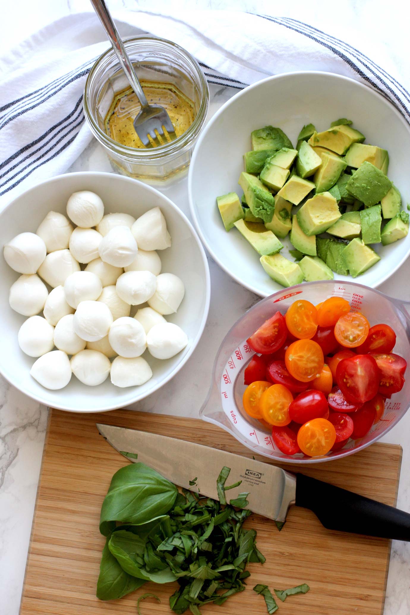 Ingredients to make a tomato mozzarella avocado salad.