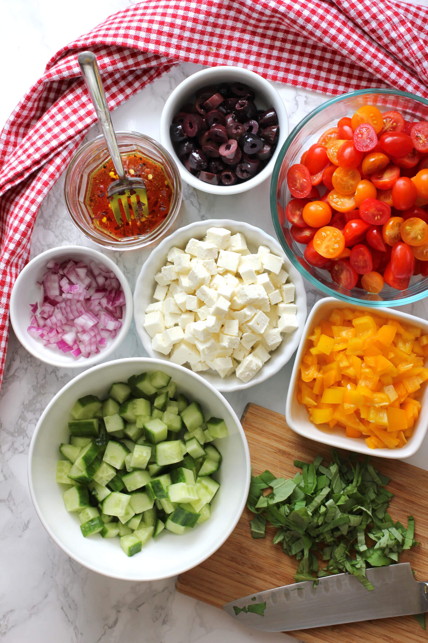 Ingredients cut up for greek pasta salad.