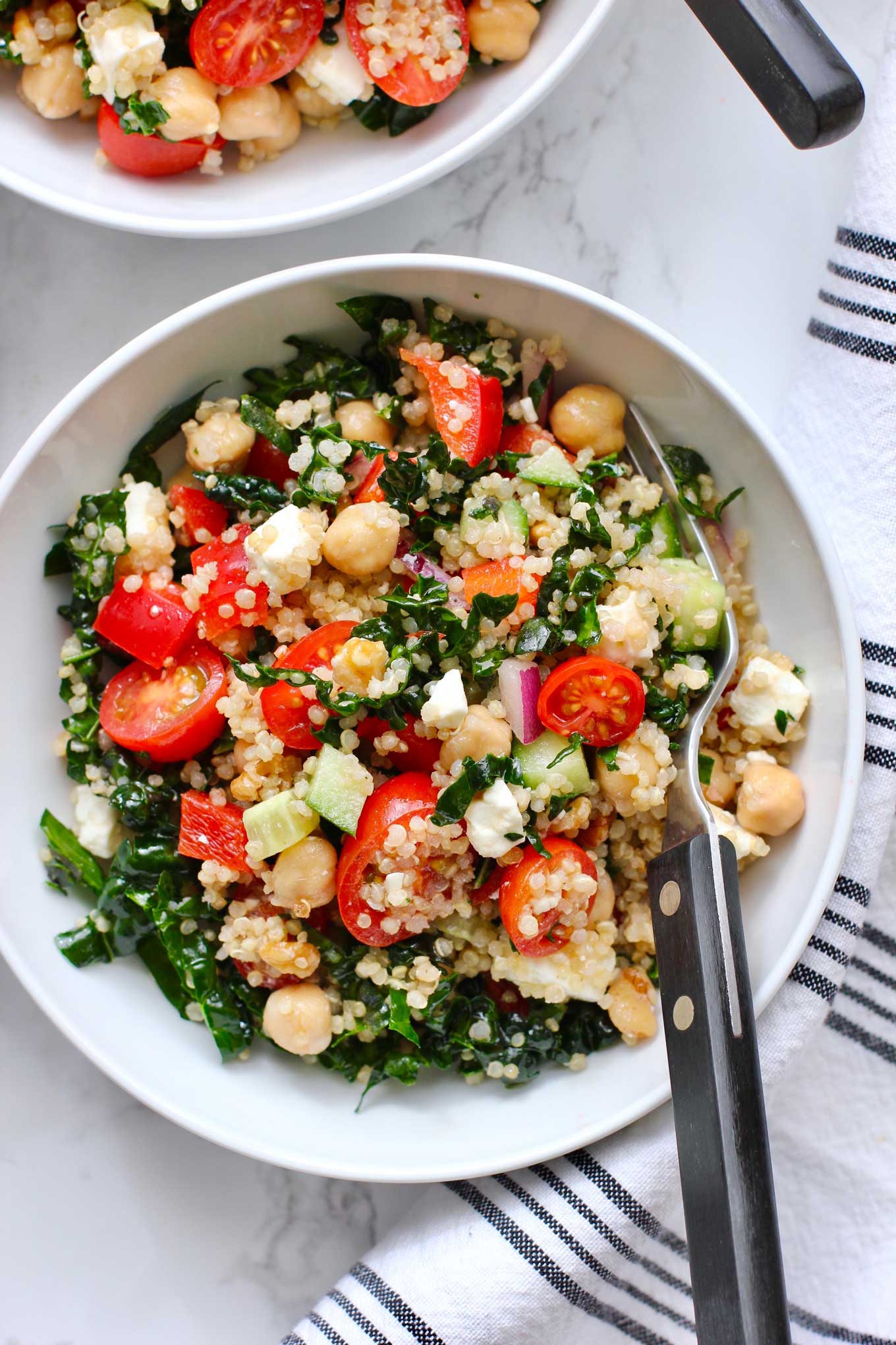 White bowl and fork with quinoa salad.